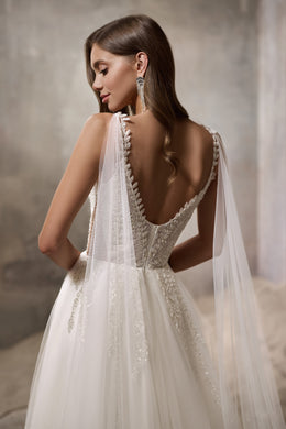 Low scoop back with sparkling trim and full flowing skirt on an ivory wedding dress