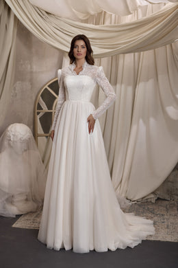 Ivory A-line wedding dress with a high neckline, long beaded lace sleeves, fitted bodice, and softly gathered skirt