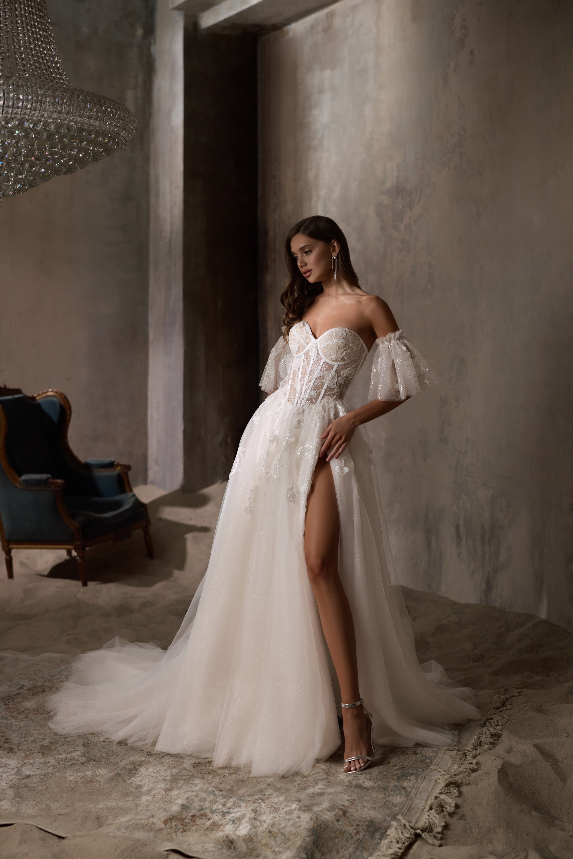 Ivory wedding dress with puff sleeves, a thigh-high slit, and a sparkling A-line skirt