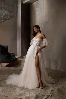 Ivory wedding dress with puff sleeves, a thigh-high slit, and a sparkling A-line skirt