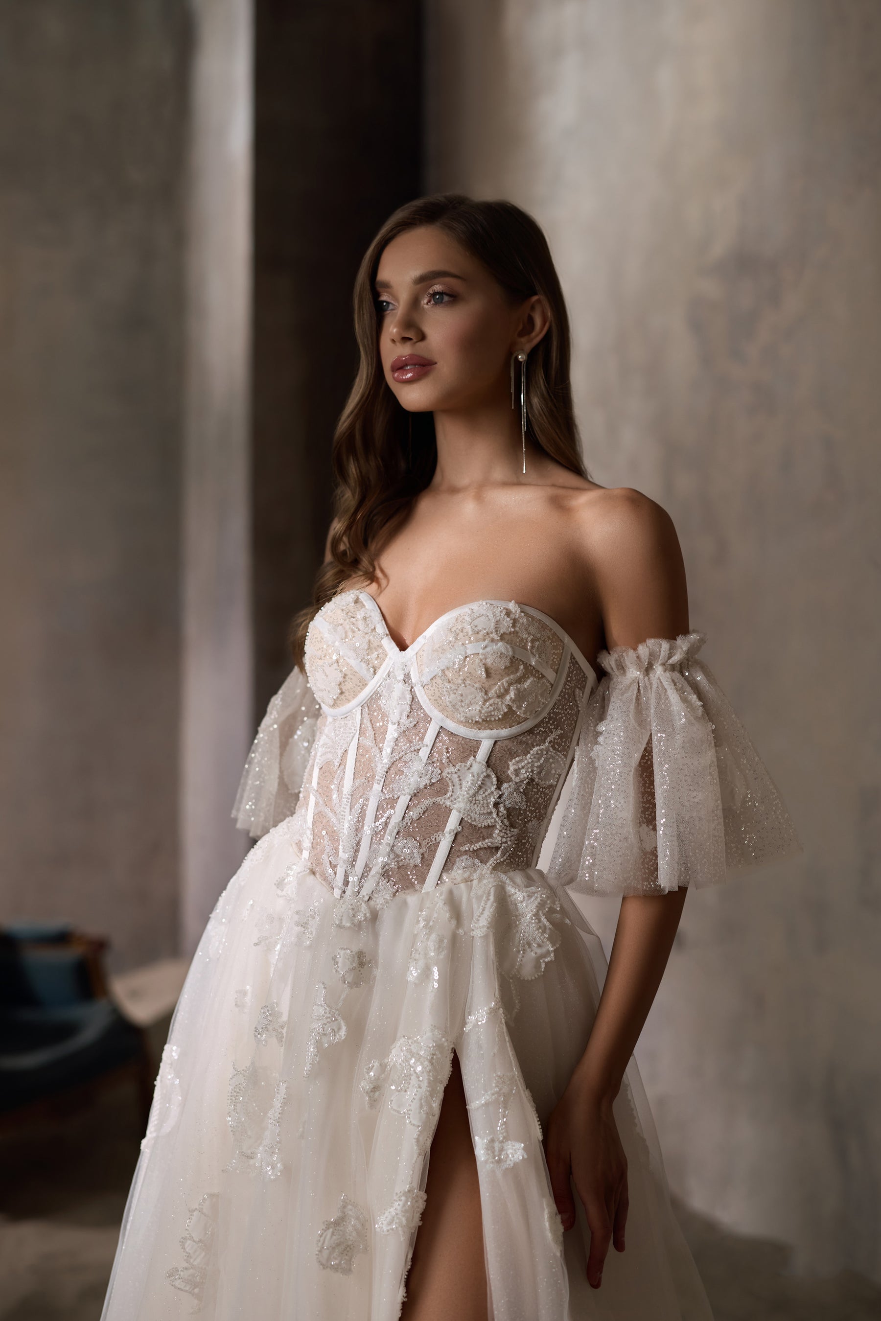 Close-up of an ivory wedding dress bodice with a sweetheart neckline, puff sleeves, and floral sparkle