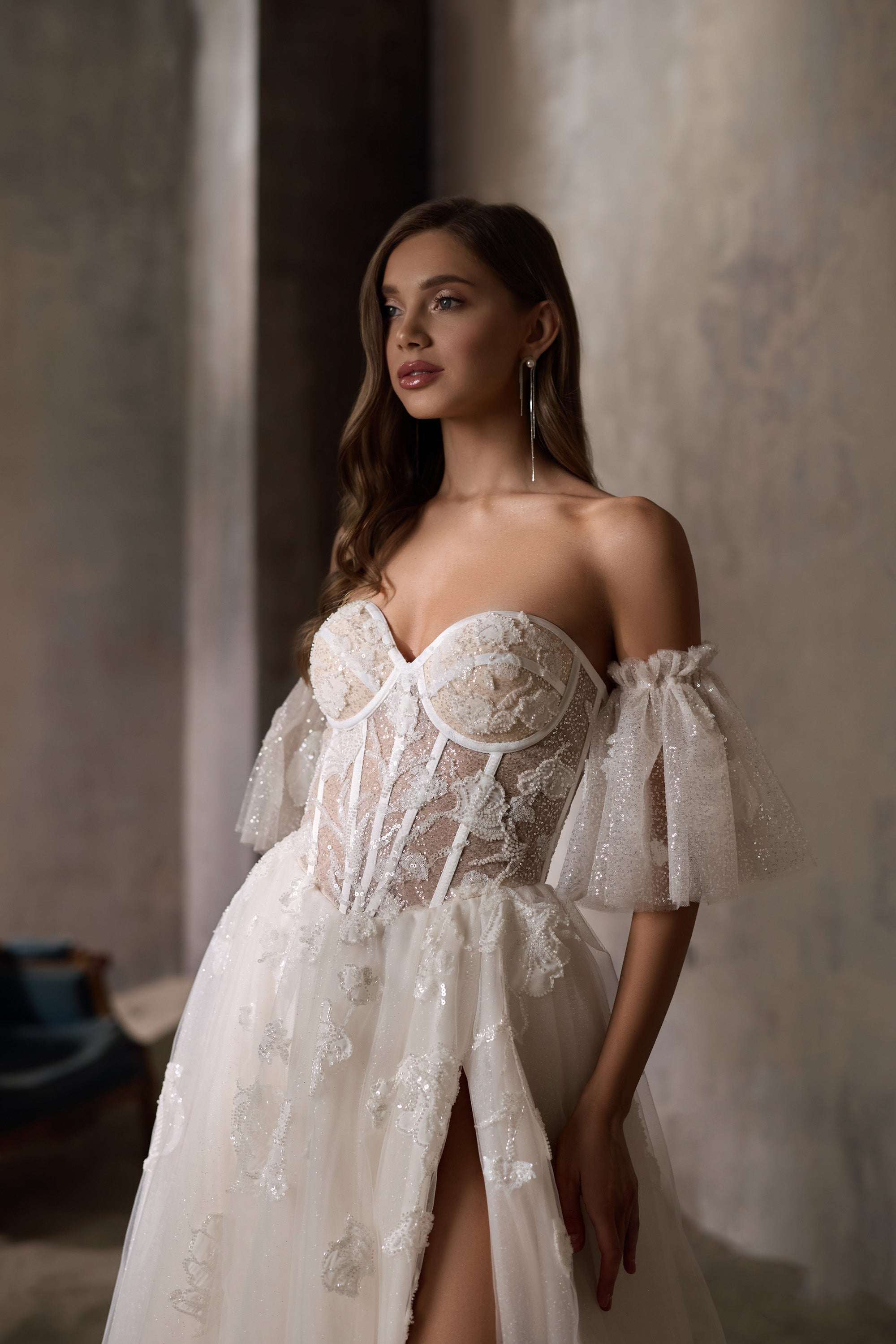 Close-up of an ivory wedding dress bodice with a sweetheart neckline, puff sleeves, and floral sparkle