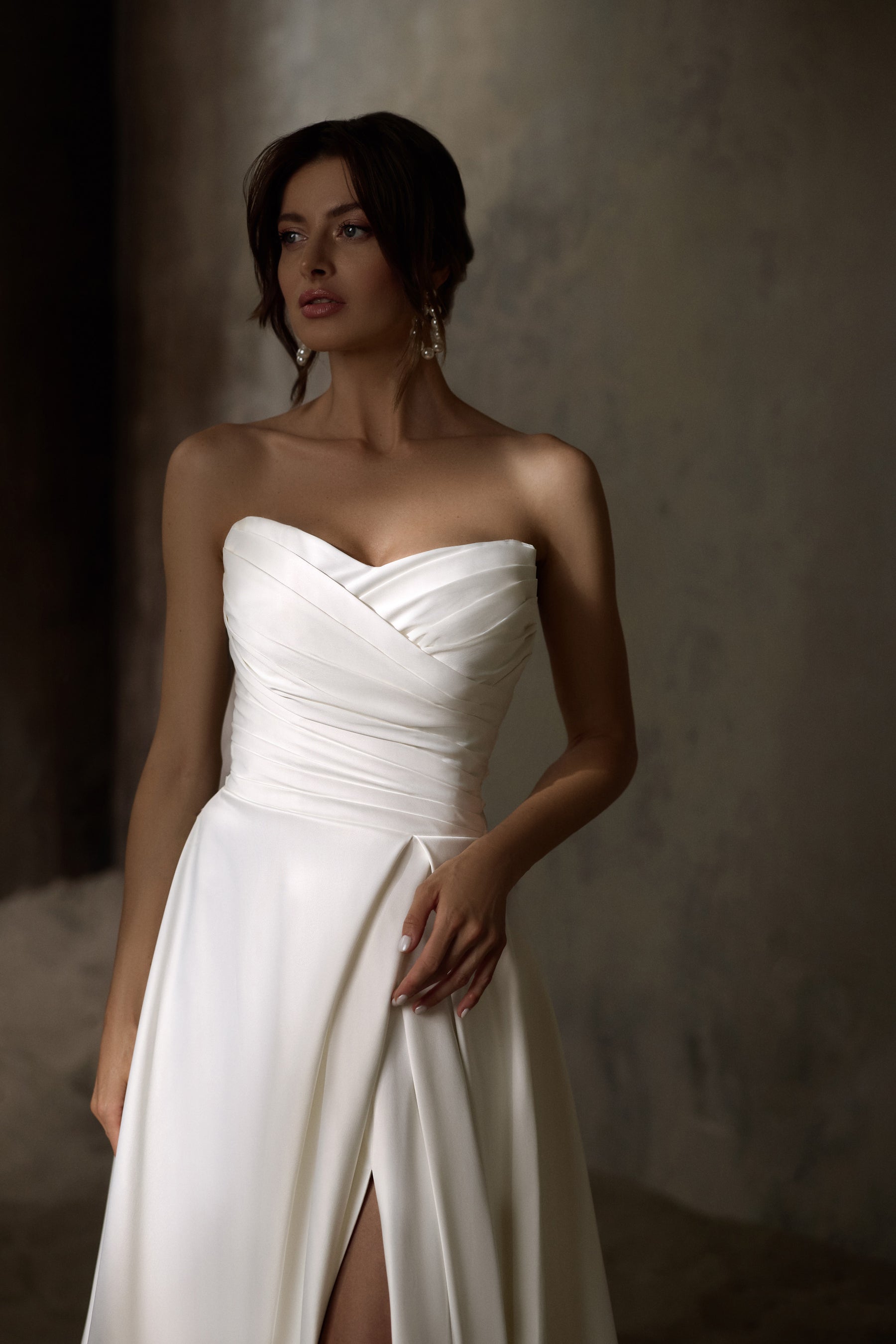 Ivory strapless wedding dress with a draped sweetheart bodice, A-line skirt, and front slit
