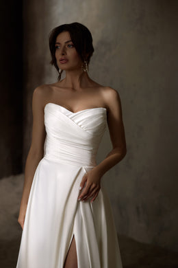 Ivory strapless wedding dress with a draped sweetheart bodice, A-line skirt, and front slit