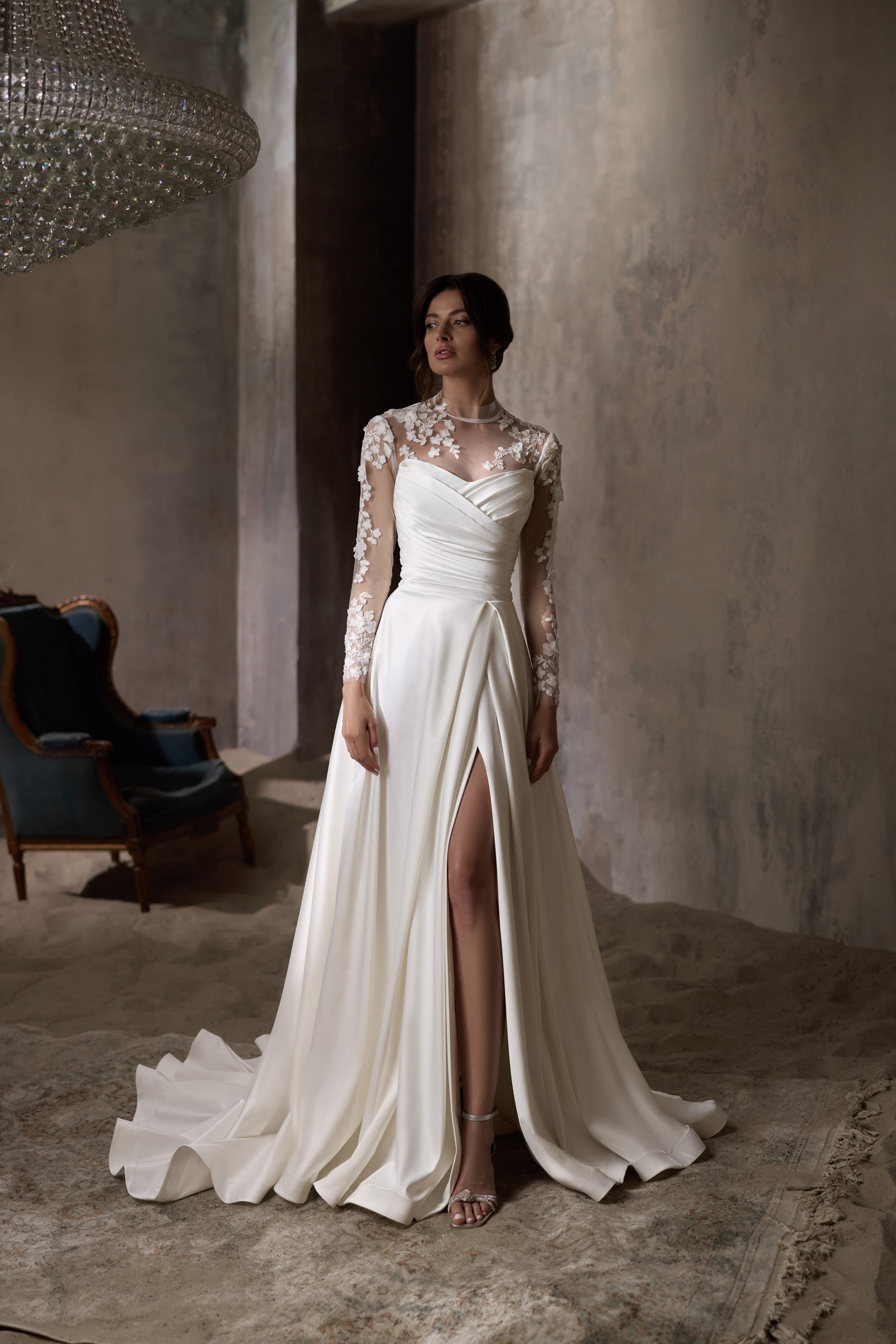 Ivory wedding dress with sheer floral lace long sleeves, a front slit, and a sweeping train