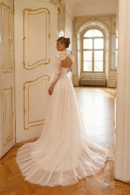 Open-back ivory wedding dress with lace detailing, a sheer high-neck bolero, and a long flowing train