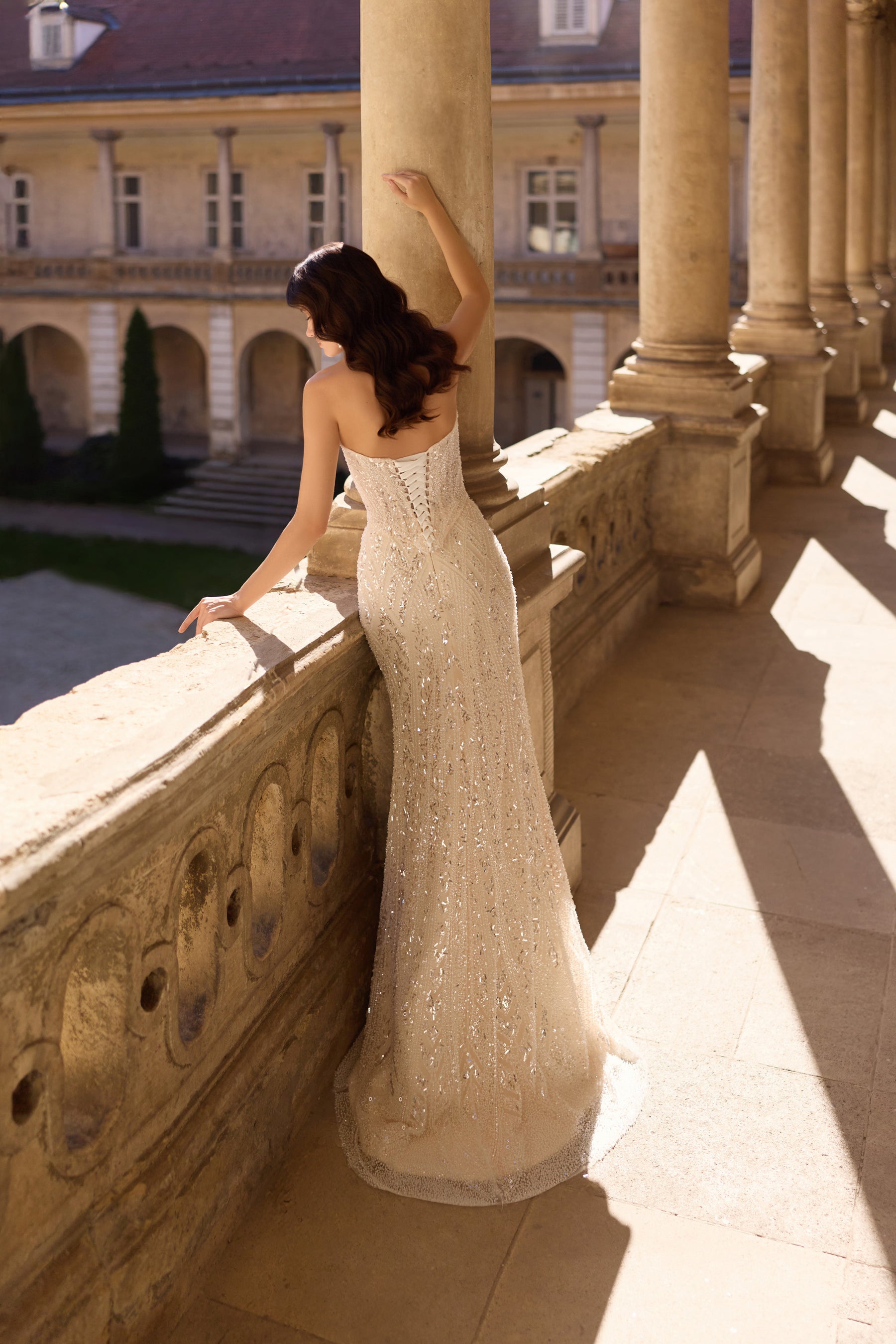 Open square back and glittering fitted skirt on an ivory wedding dress with a soft train