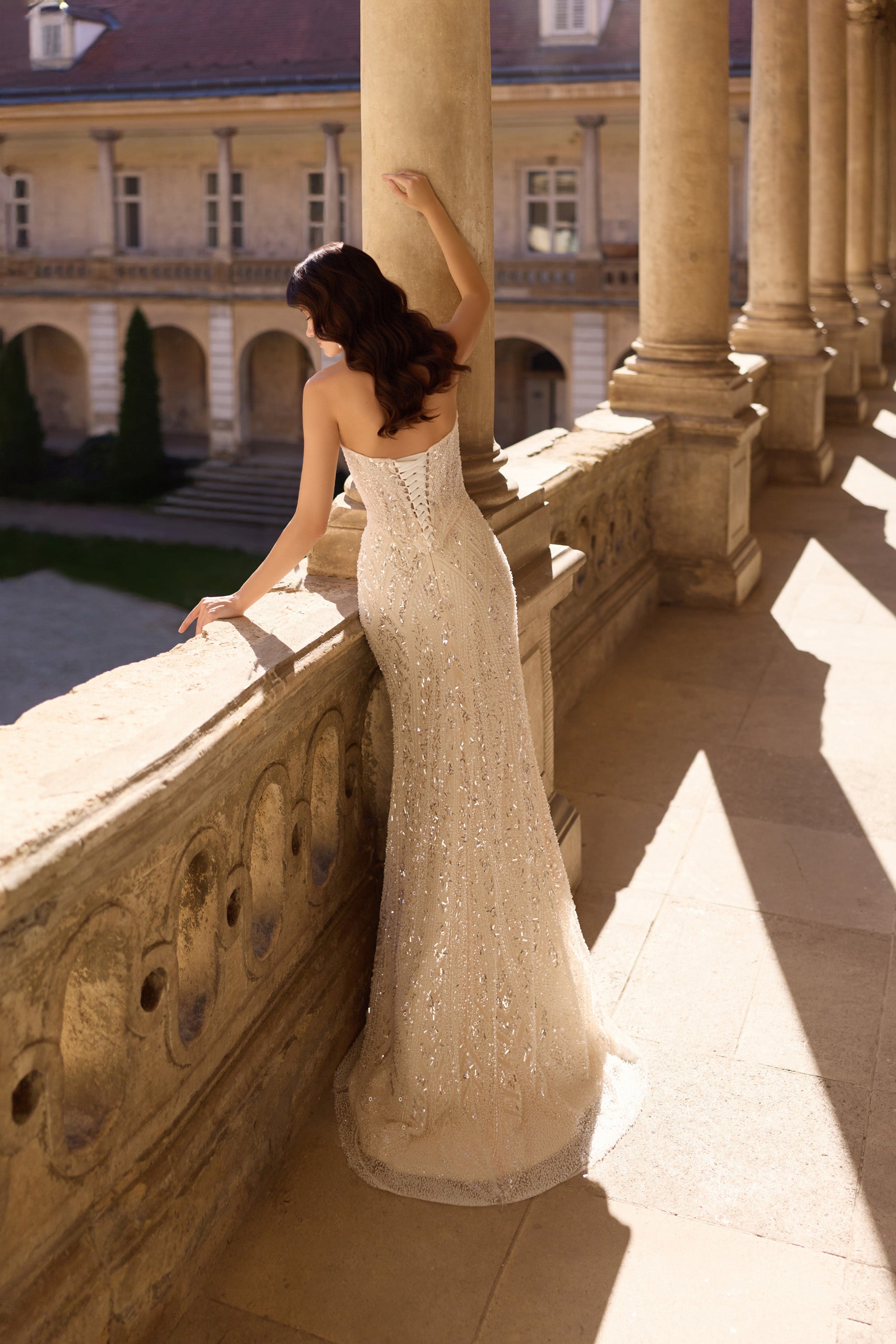 Open square back and glittering fitted skirt on an ivory wedding dress with a soft train