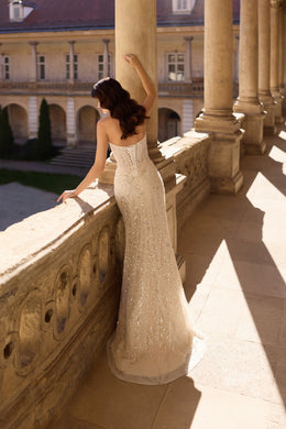 Open square back and glittering fitted skirt on an ivory wedding dress with a soft train
