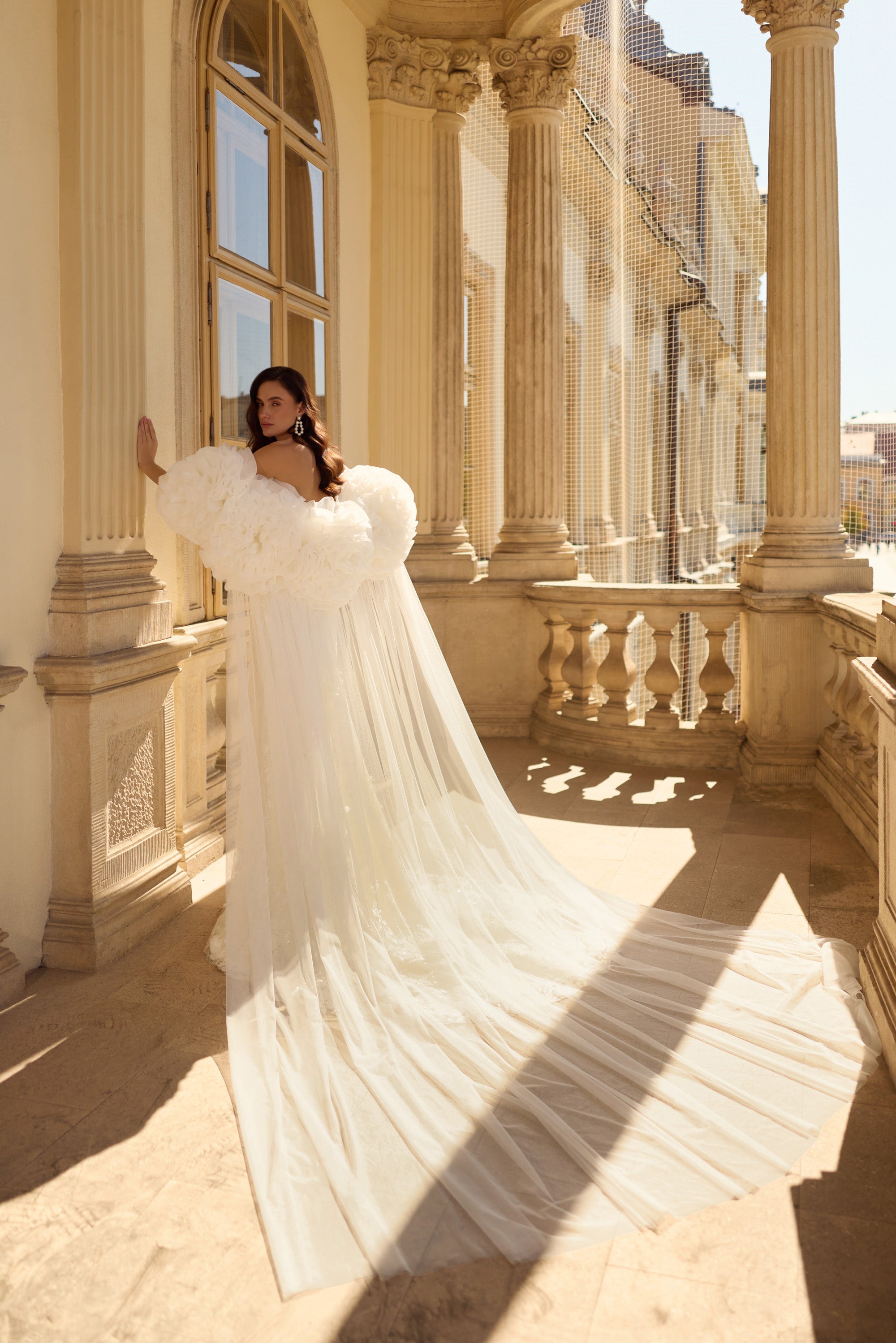 Ivory wedding dress with voluminous floral sleeves, fitted mermaid silhouette, and long train