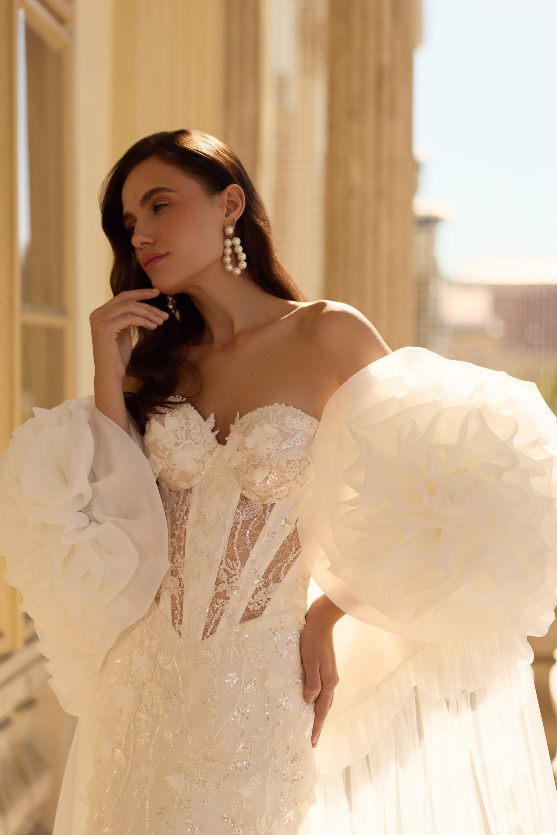 Close-up of a beaded sweetheart bodice and oversized floral puff sleeves on a wedding dress