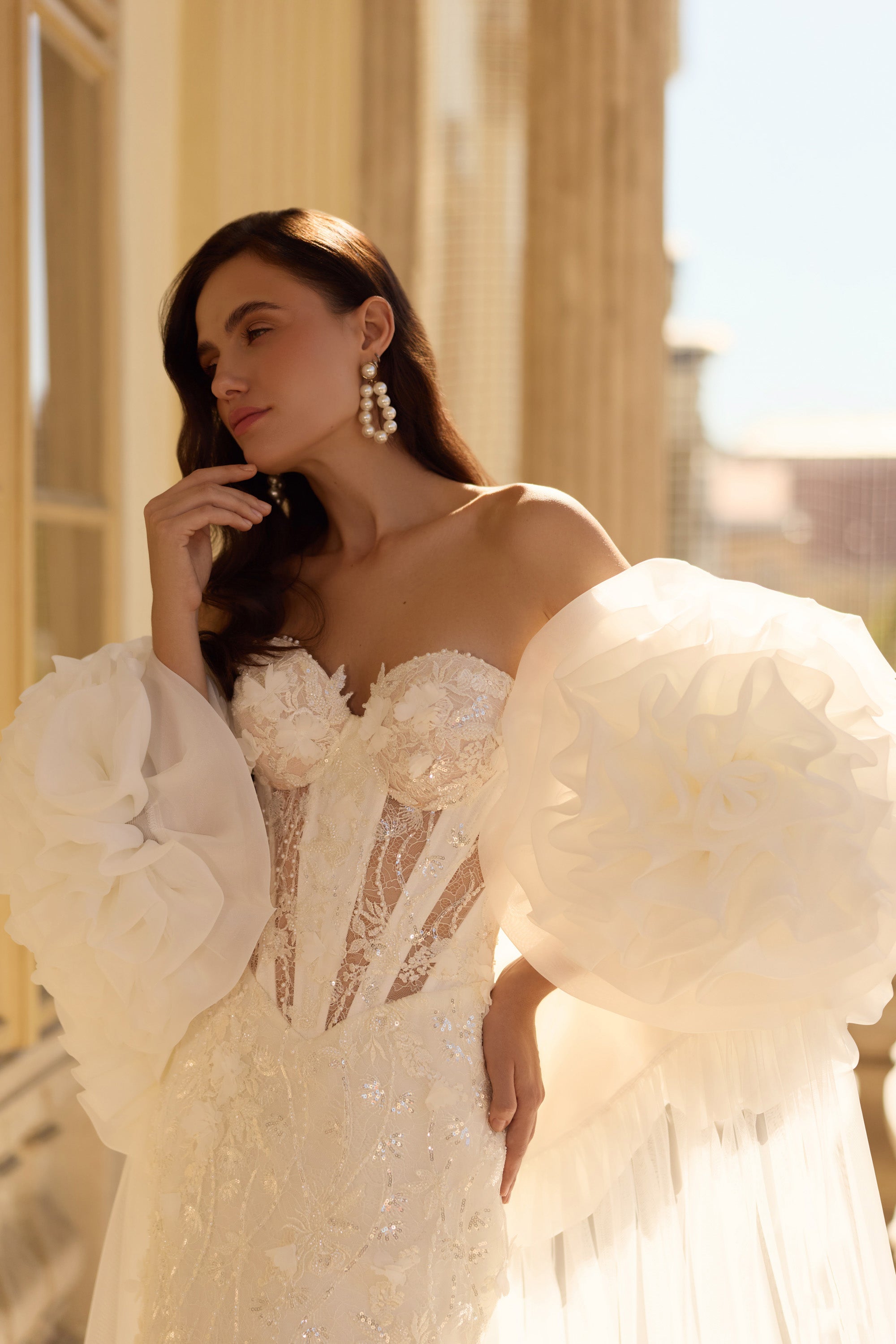 Close-up of a beaded sweetheart bodice and oversized floral puff sleeves on a wedding dress