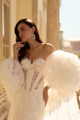Close-up of a beaded sweetheart bodice and oversized floral puff sleeves on a wedding dress