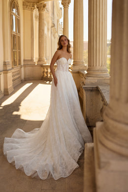 Strapless ivory wedding dress with a sweetheart neckline, lace-covered bodice, A-line skirt, and long train