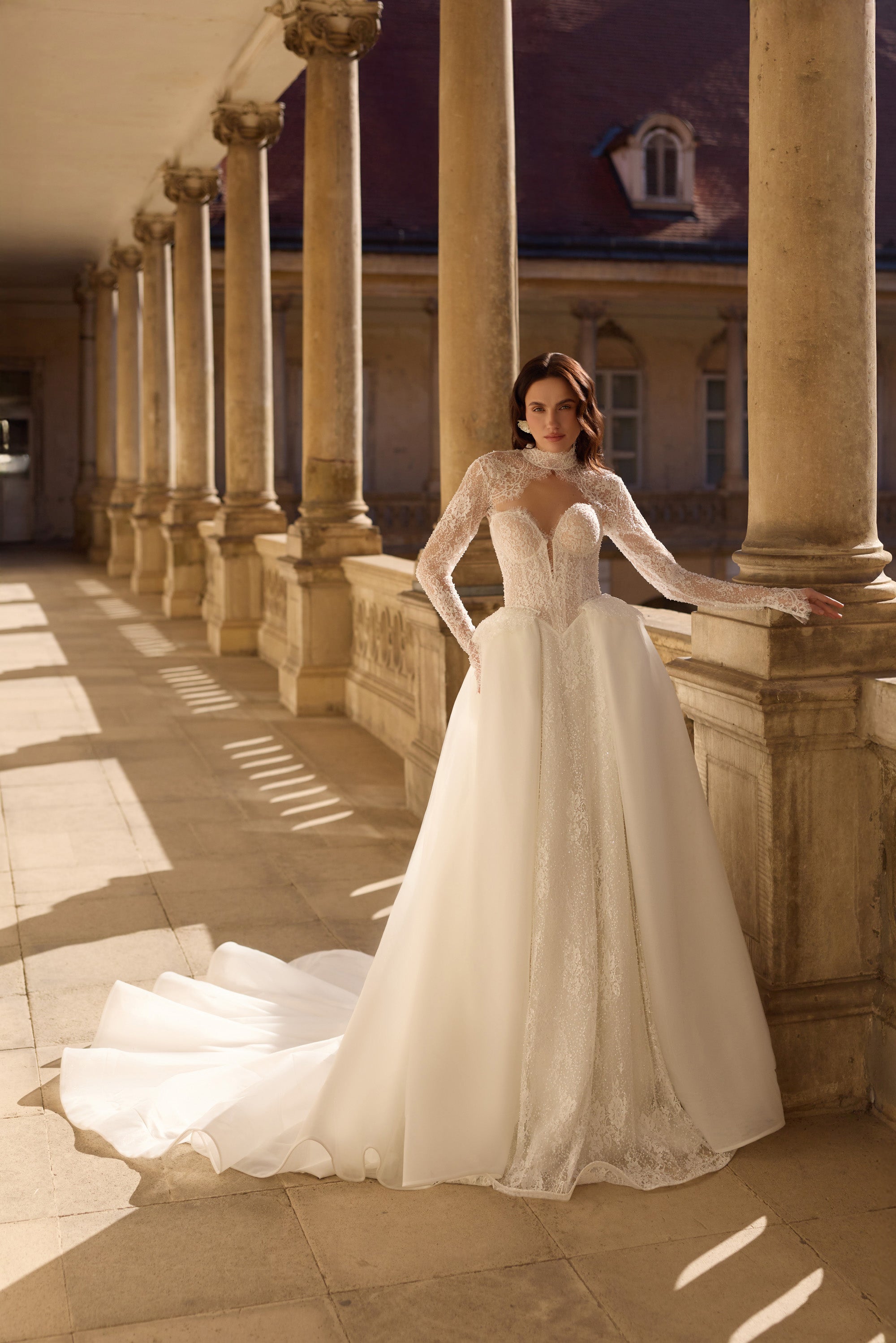 Ivory A-line wedding dress with long illusion lace sleeves, a sweetheart bodice, and a flowing train