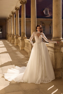 Ivory A-line wedding dress with long illusion lace sleeves, a sweetheart bodice, and a flowing train