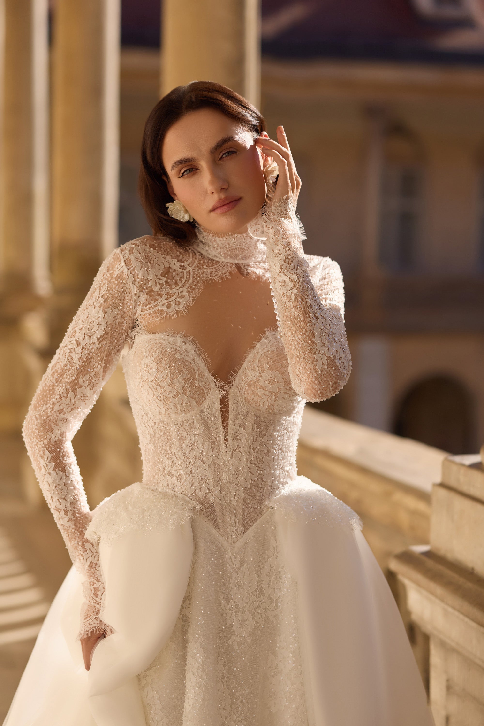 Ivory wedding dress featuring a high illusion lace neckline, long sleeves, defined waist, and full skirt