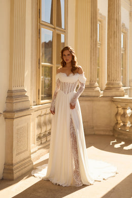 Ivory wedding dress with an off-the-shoulder neckline, sheer lace sleeves, beaded corset, and flowing train