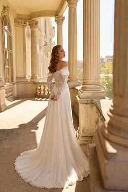 Ivory wedding dress showing a lace-up back, long sleeves, and a sweeping chapel-length train