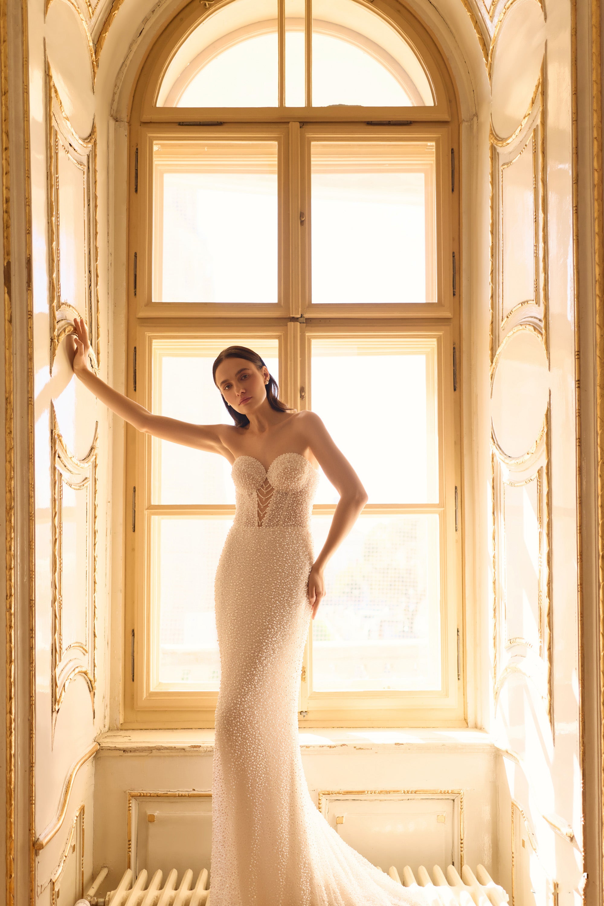 Fitted strapless mermaid wedding dress covered in beadwork with a sweeping train