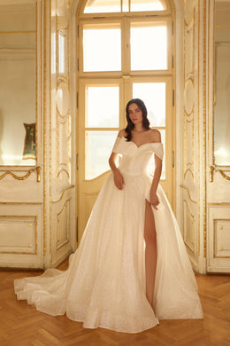 Sparkling ivory ball gown wedding dress with an off-the-shoulder neckline, thigh-high slit, and sweeping train