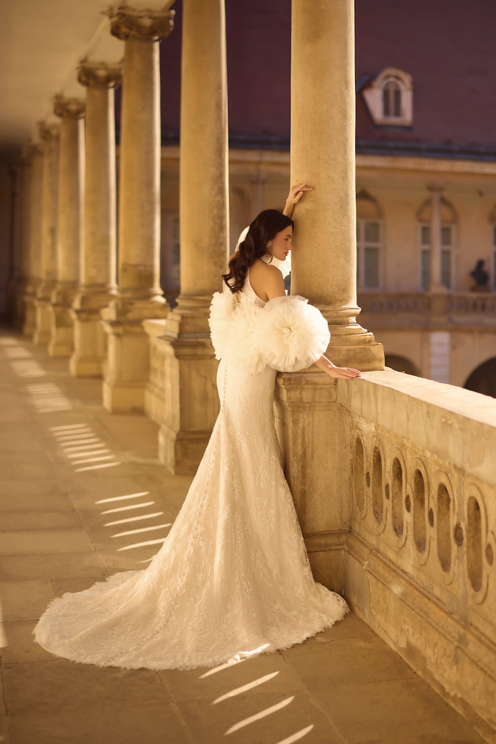Ivory lace wedding dress with detachable tulle puff sleeves, fitted mermaid skirt, and sweeping train