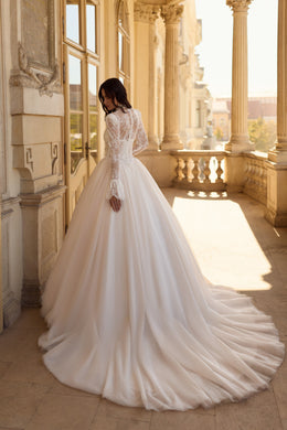 Ivory wedding dress with a lace-covered back, long sleeves, full ball gown skirt, and sweeping train