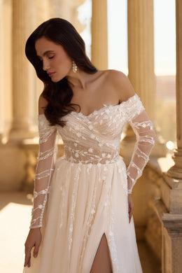 Ivory wedding dress featuring an off-the-shoulder floral lace bodice, sheer sleeves, and a front slit