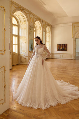 Ivory ball gown wedding dress with an illusion high neckline, long lace sleeves, and a sweeping train