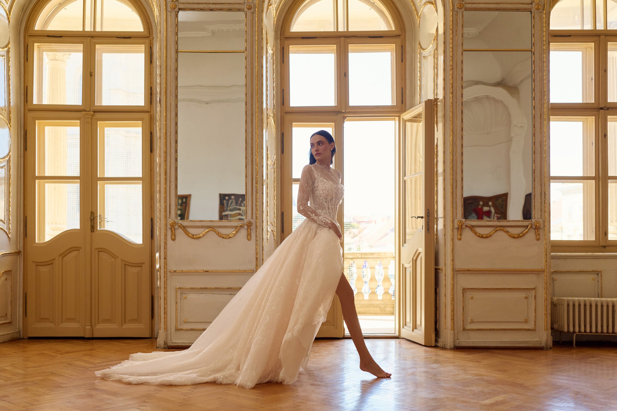 Ivory wedding dress with long lace sleeves, a full train, and a high side slit revealing the leg