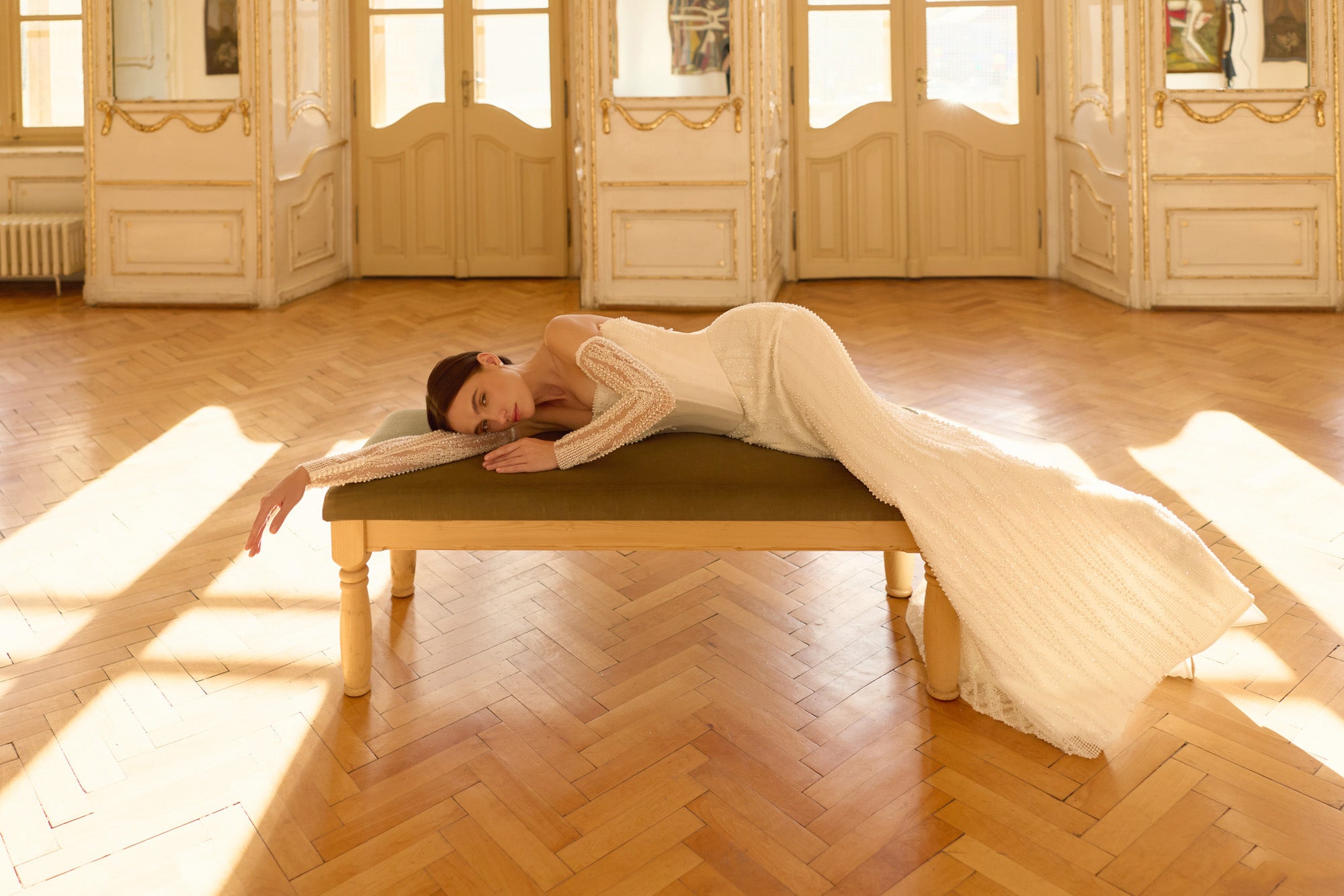 Ivory wedding dress with a fitted mermaid silhouette, shimmering beadwork, and an extended train