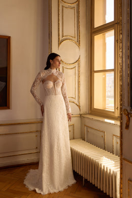 Ivory sheath wedding dress with long lace sleeves, high neckline, fitted bodice, and trailing train