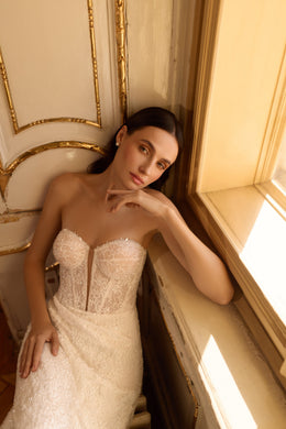 Close-up of an ivory wedding dress with a strapless sweetheart corset bodice and sparkling lace texture