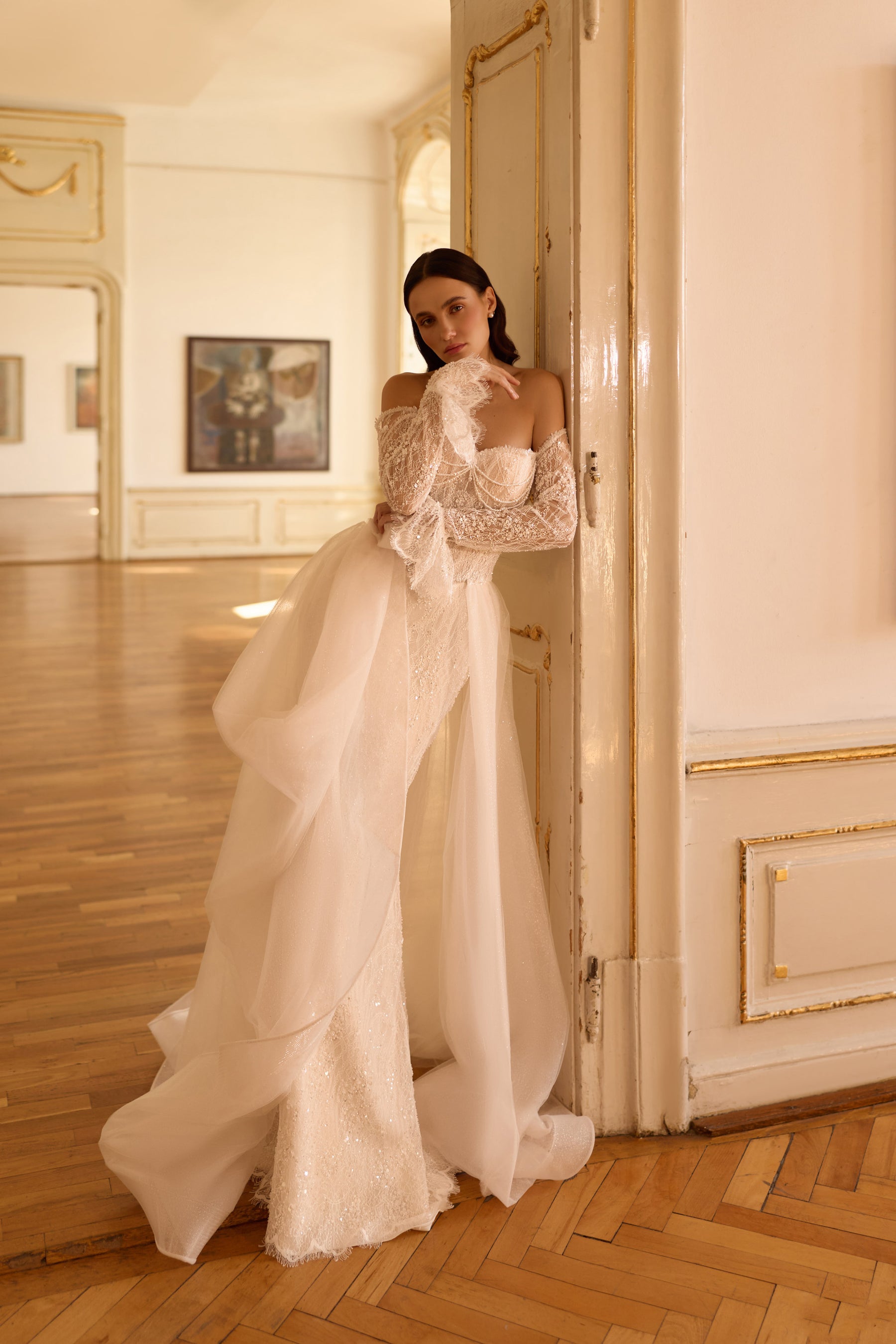 Ivory wedding dress with a sparkling fitted gown and voluminous sheer overskirt cascading into a long train