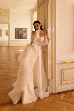 Ivory wedding dress with a sparkling fitted gown and voluminous sheer overskirt cascading into a long train