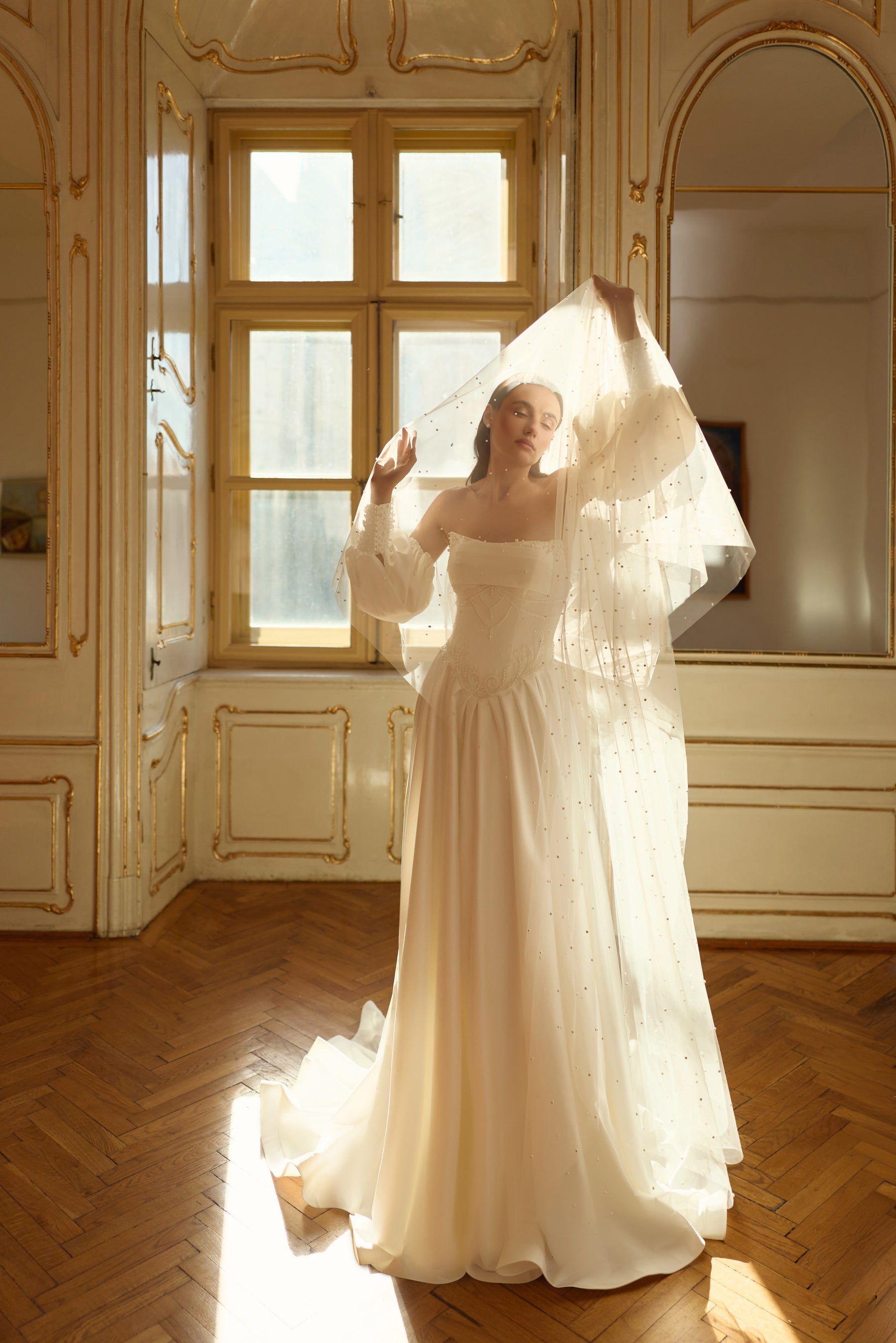 Full-length ivory A-line wedding dress with puff sleeves, flowing skirt, and long train