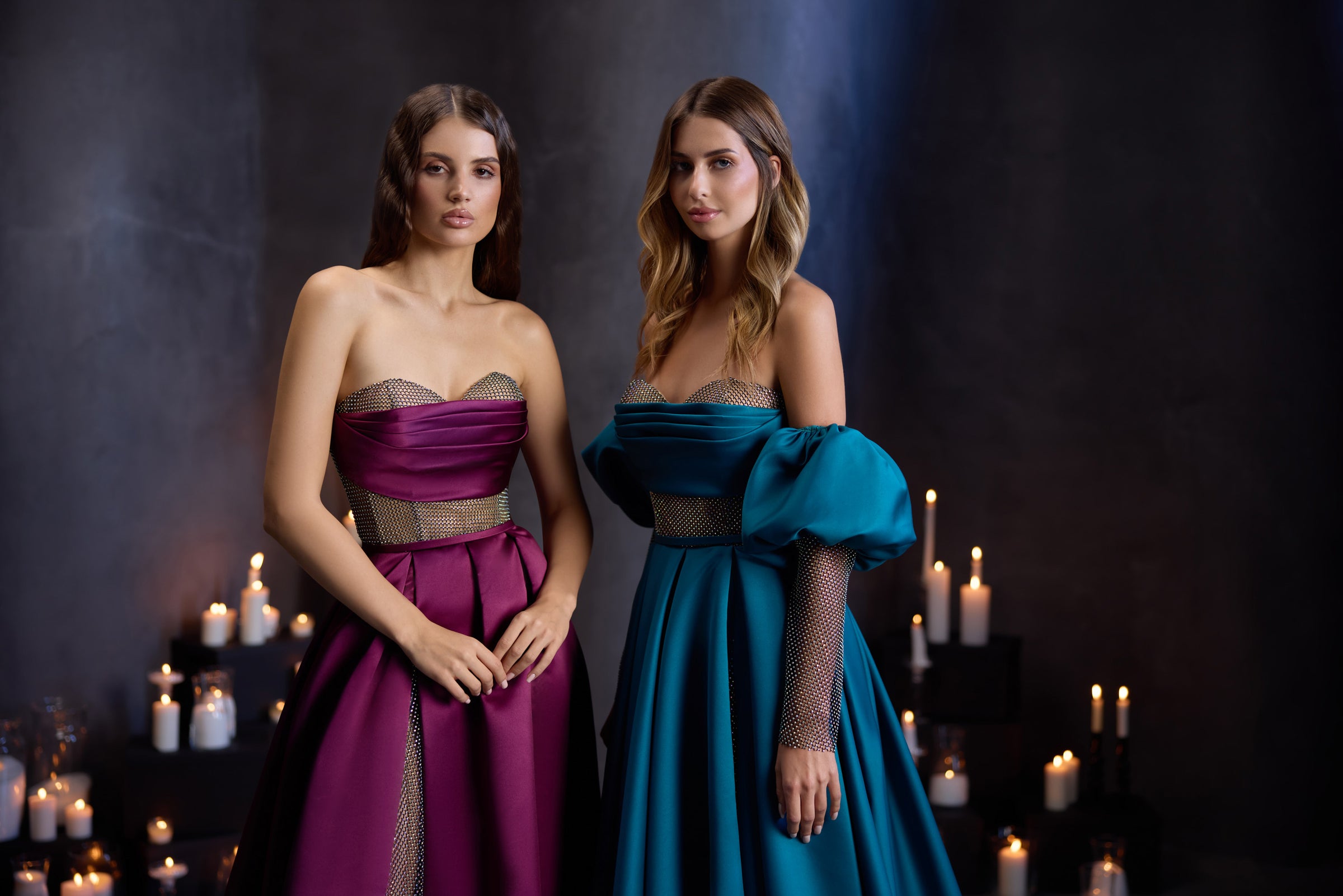 Two floor-length evening dresses with jeweled waistbands, off-shoulder sleeves, and shimmering mesh panels