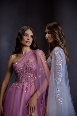 Close-up of a pink evening dress with a beaded bodice, one-shoulder sheer drape, and gathered A-line skirt