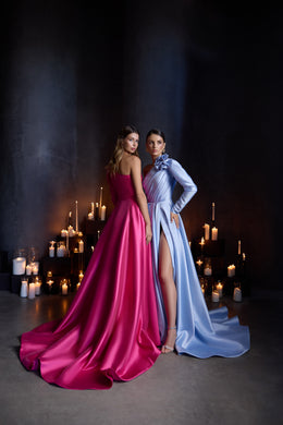 Pink evening dress with a long flowing train beside a blue long-sleeve dress with a thigh-high slit