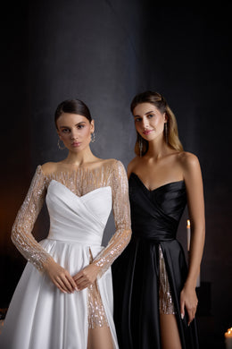 White evening dress featuring a draped sweetheart bodice, sheer beaded long sleeves, and high slit