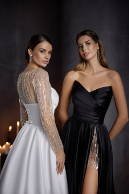 White evening dress showing a sheer beaded back, long sleeves, fitted waist, and flowing A-line skirt