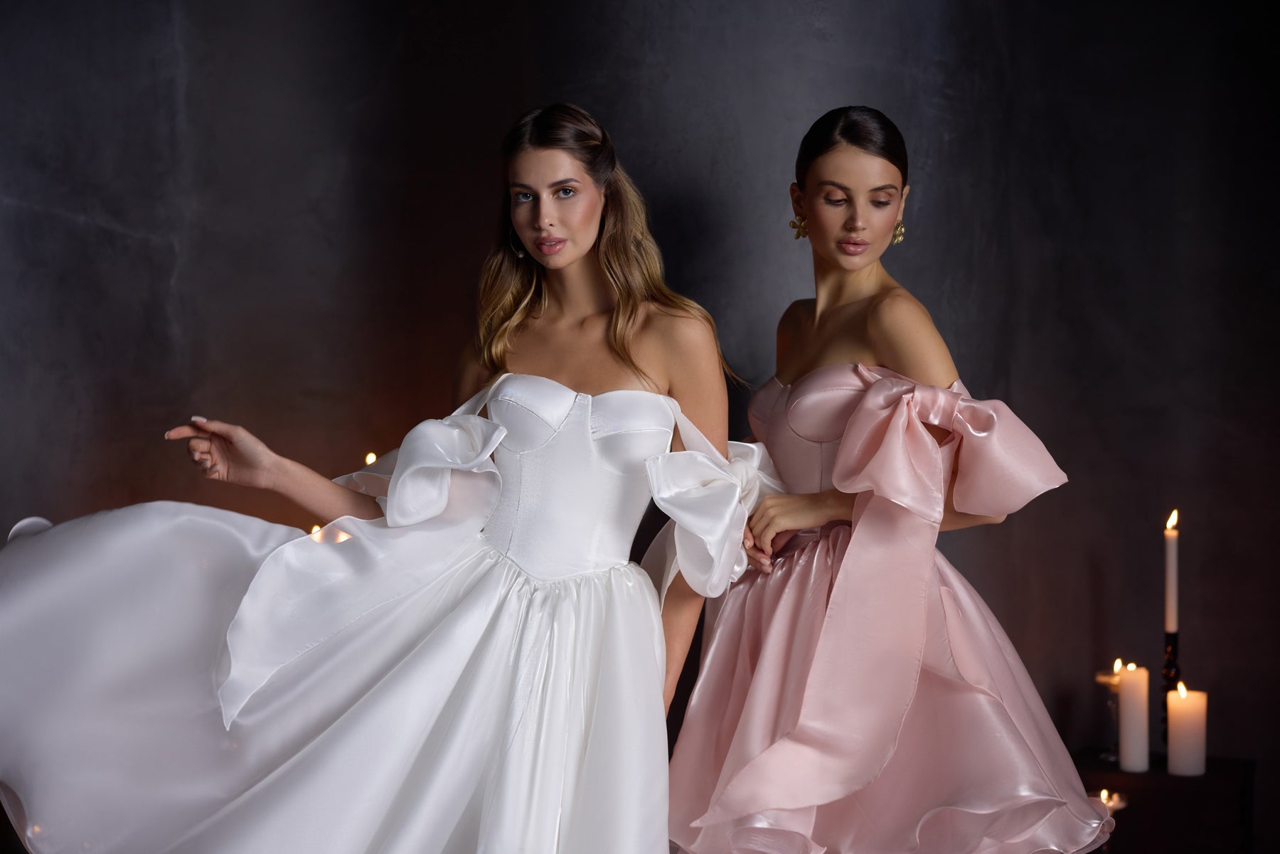 Blush pink evening dress featuring voluminous bow sleeves, a fitted bodice, and a flared ruffled skirt