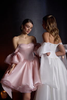 Blush pink evening dress with a strapless sweetheart neckline and oversized bow sleeves