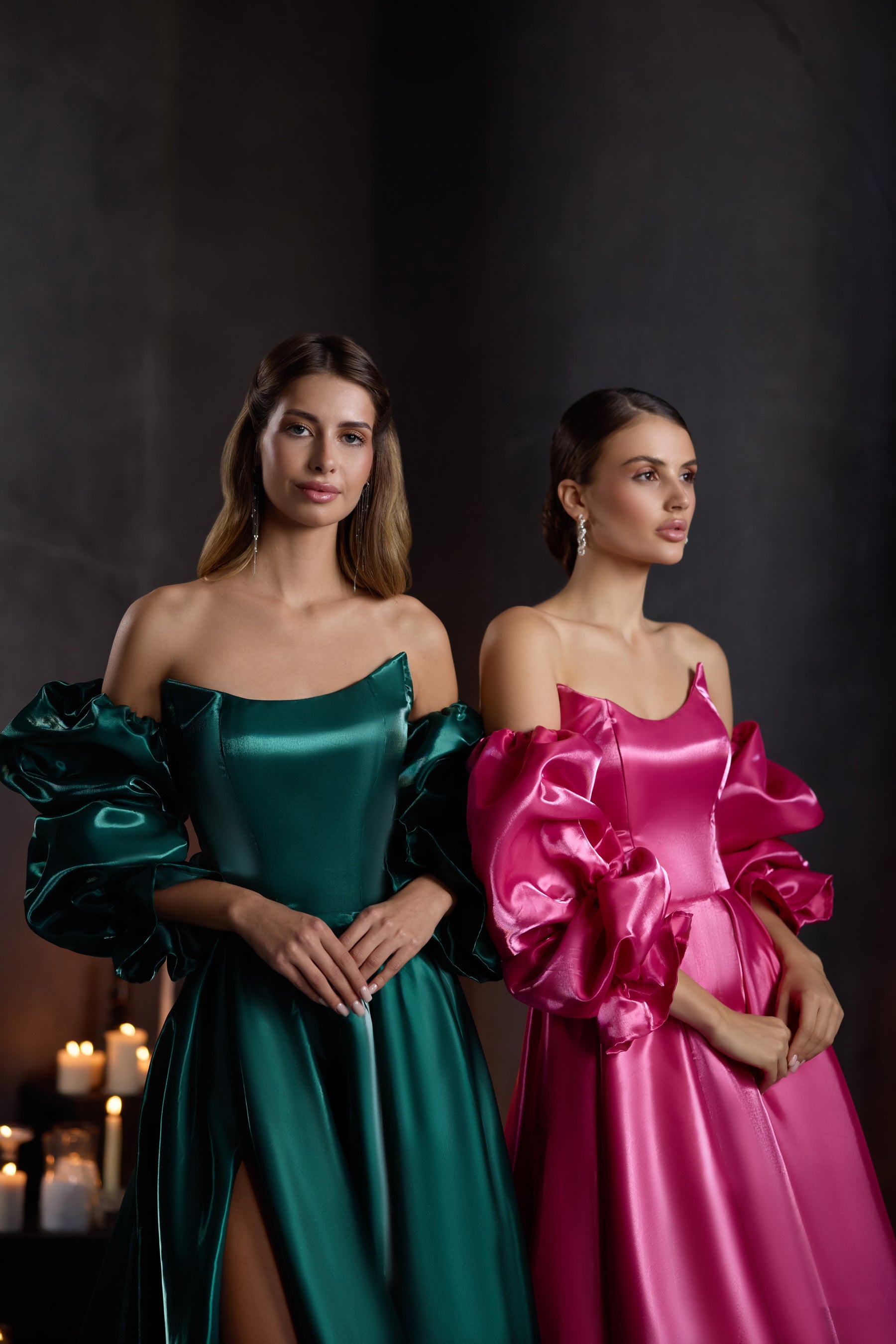 Close-up of emerald green and fuchsia pink evening dresses with sweetheart necklines and voluminous puff sleeves