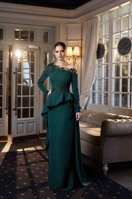 Emerald green evening dress with long sleeves, an embellished neckline, peplum waist, and trailing skirt