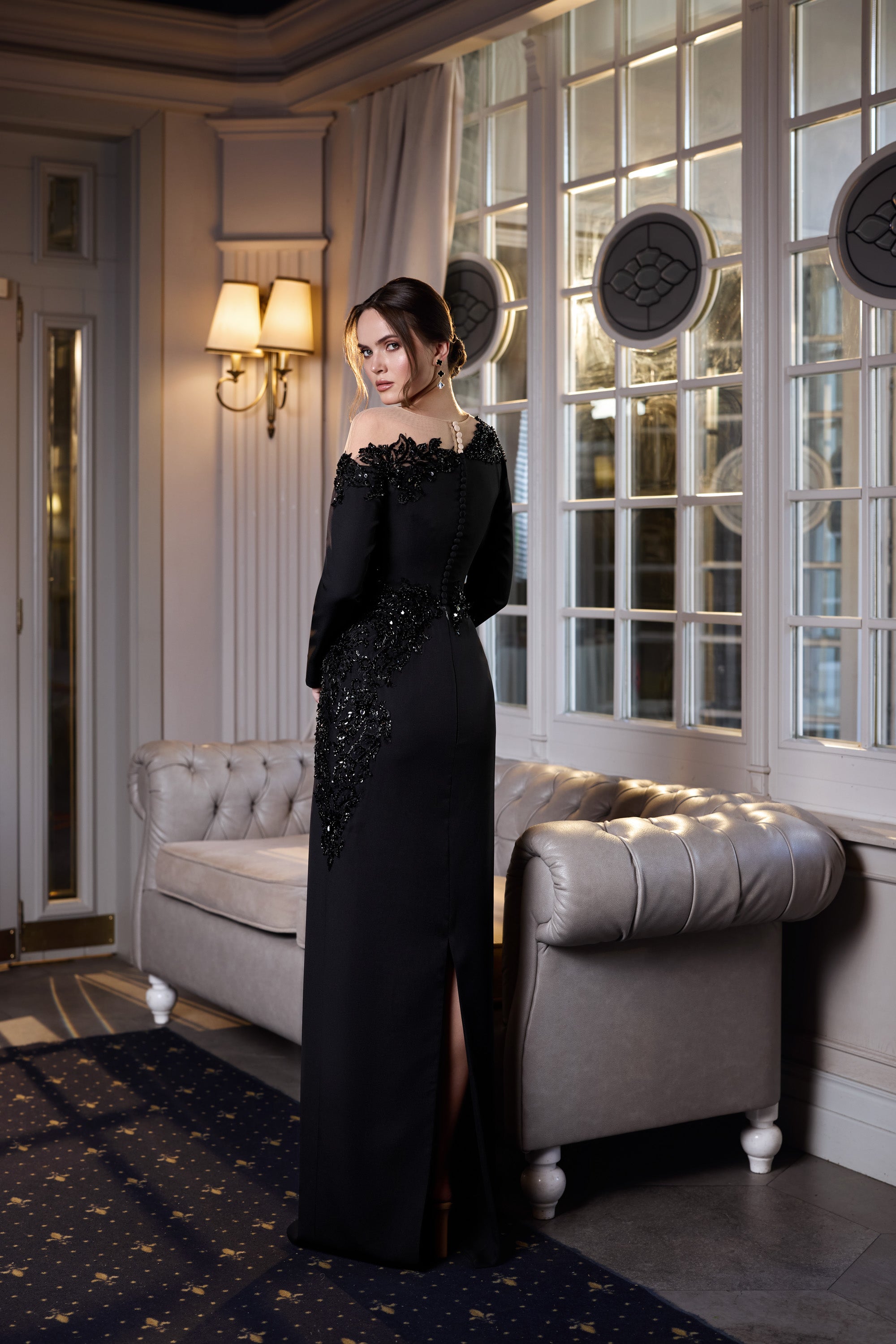 Black evening dress with a fitted silhouette, embellished waist and hip, and a high side slit