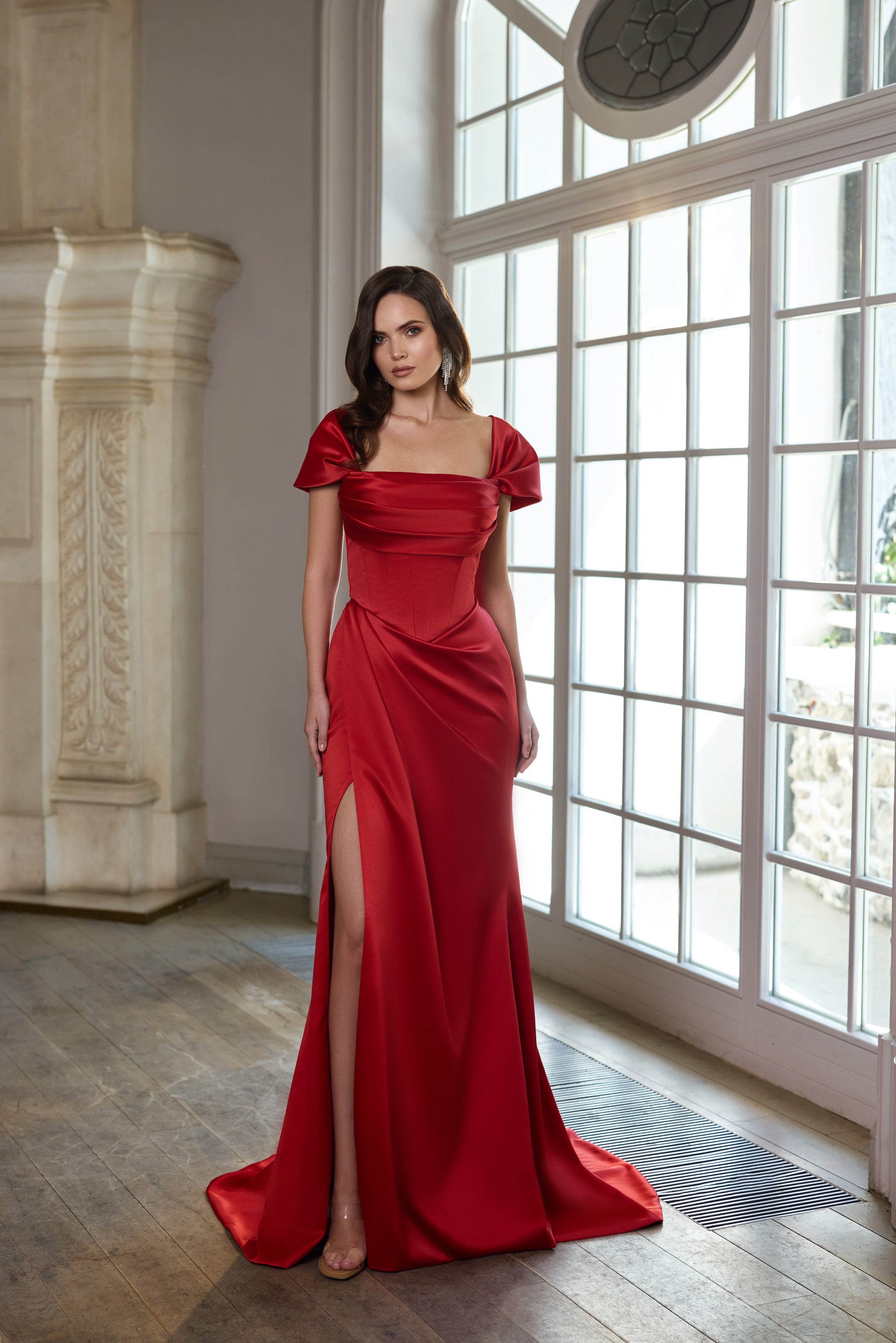 Red evening dress with draped square neckline, puff sleeves, fitted waist, thigh-high slit, and train