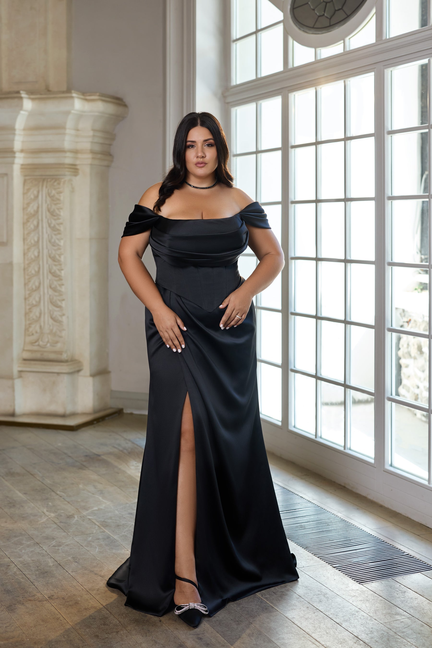Black evening dress with an off-the-shoulder neckline, fitted silhouette, and high front slit