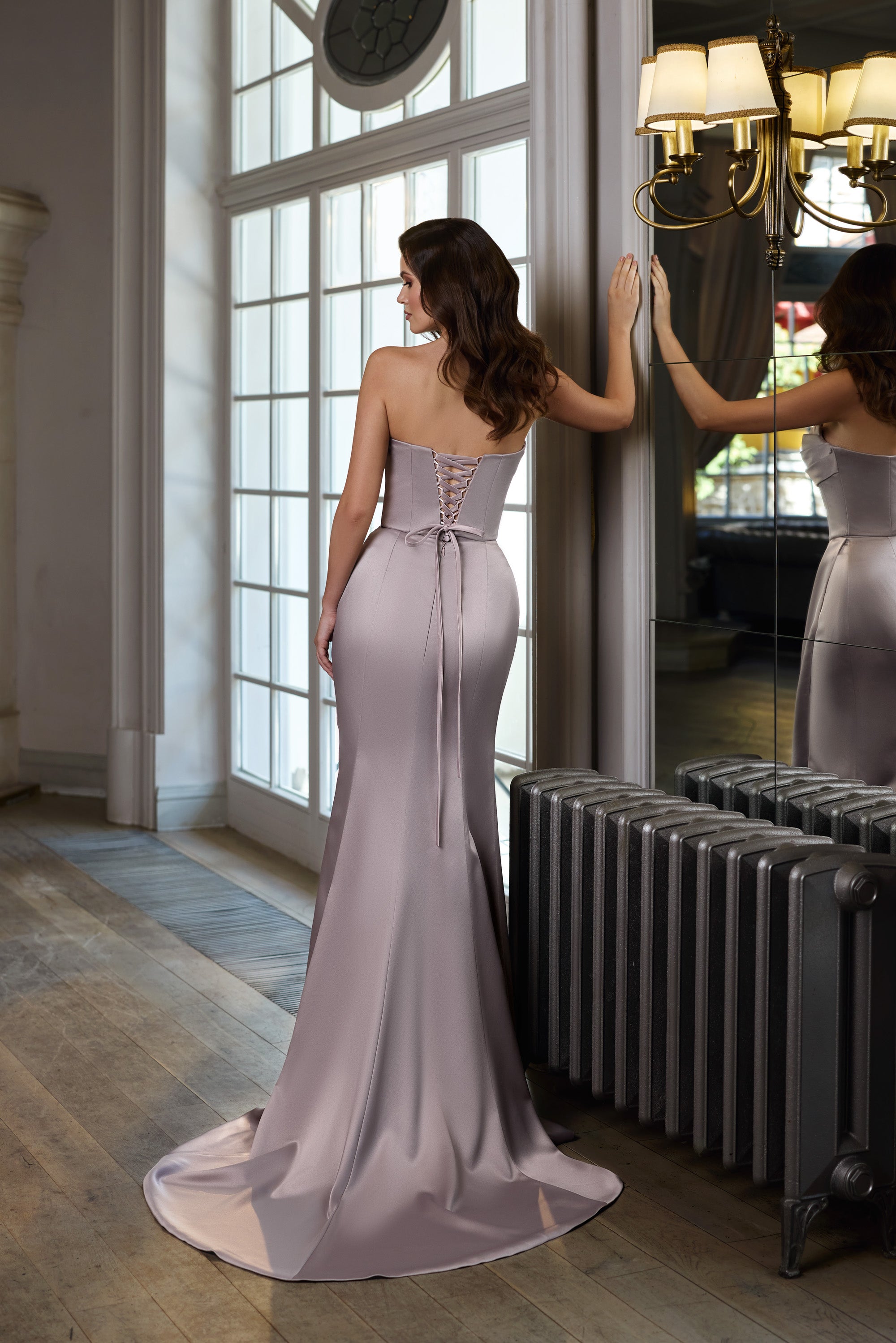 Back of a mauve evening dress with corset lacing, fitted silhouette, and sweeping train
