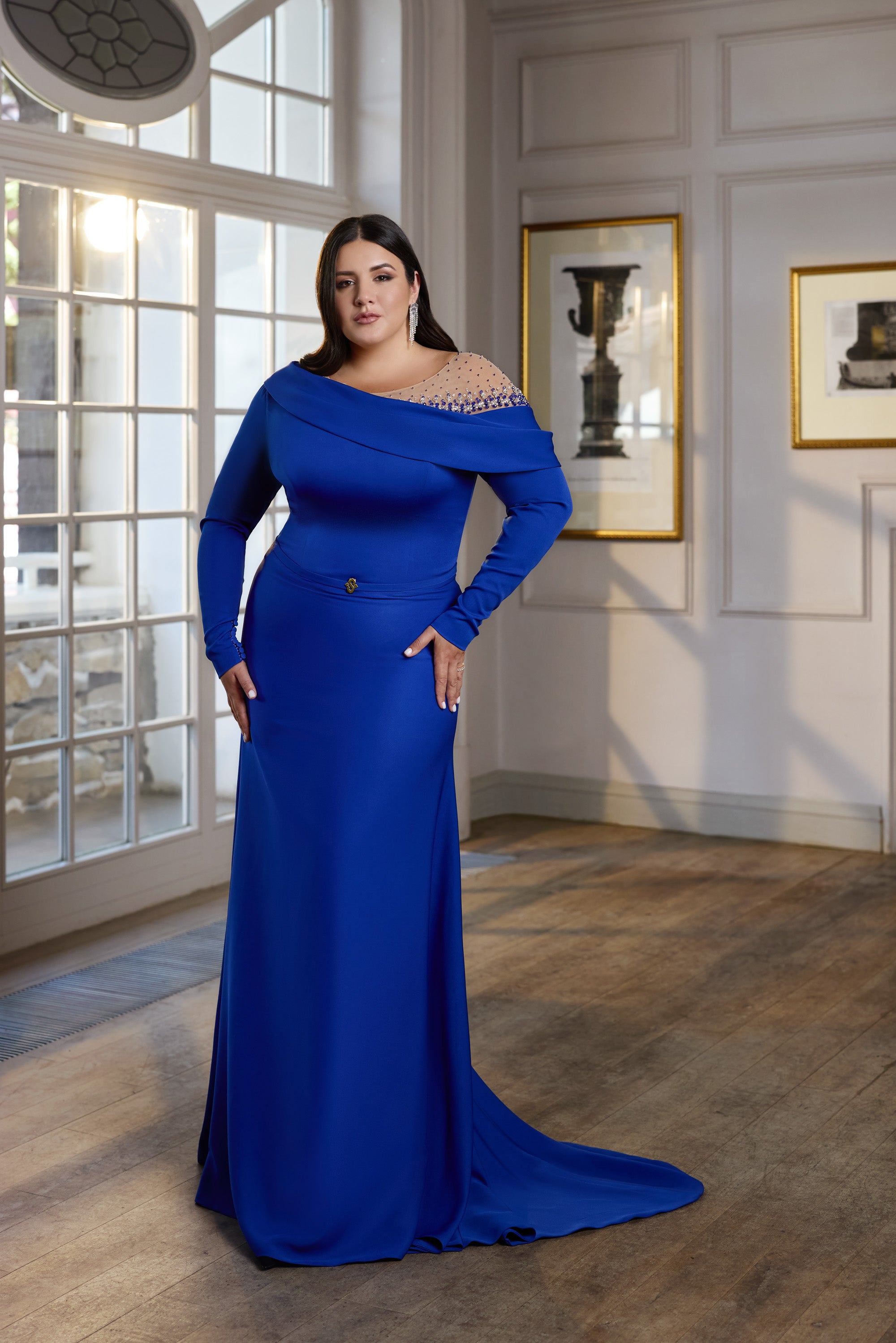 Sapphire blue evening dress with an off-shoulder draped neckline, long sleeves, fitted skirt, and train